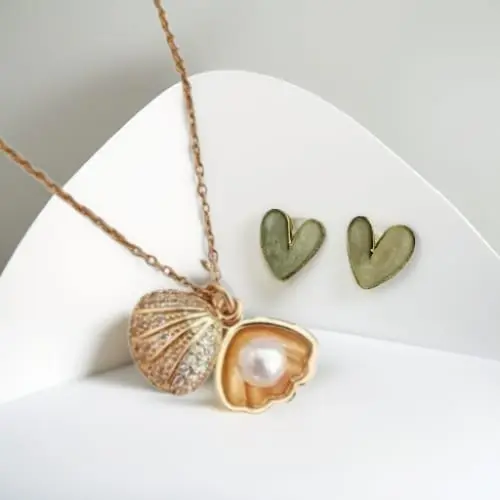Uncover hidden beauty with the Pearl Whisper Locket And Glossy White Heart Stud Earrings Combo